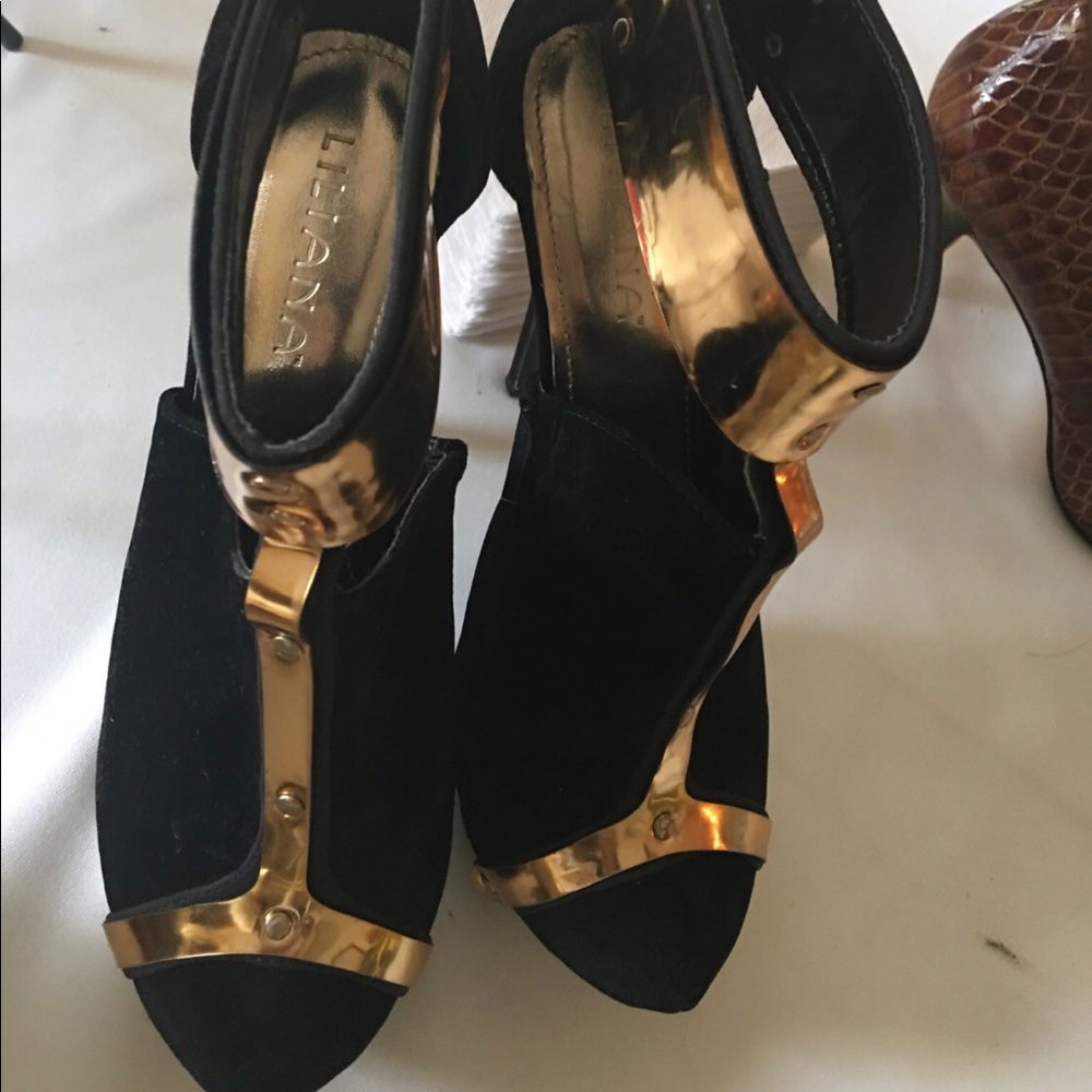 Black heels embellished with gold medal